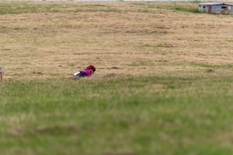 a person on a bicycle in the field, it is labeled as 'wielrennen'.