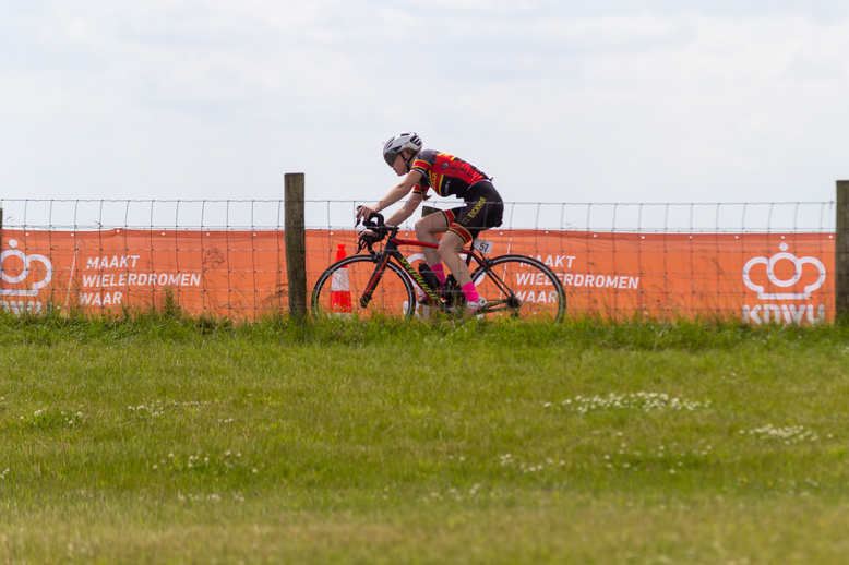 A cyclist on a track with the words NK Wielrennen 2022 Junioren Dames on it.