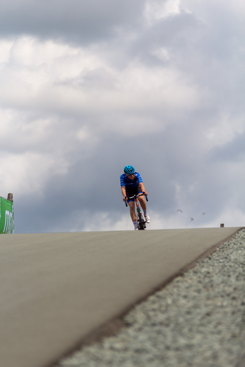 A person is riding a bike down the side of a steep hill during an event.