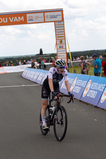 A man on a bicycle wearing a helmet and black shorts.