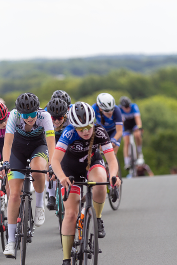 A group of women racing bicycles in a 2022 Juniors race.