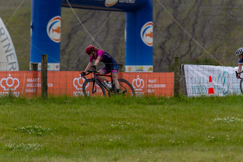 A cyclist participating in a race with the words "Junioren Dames" on their jersey.