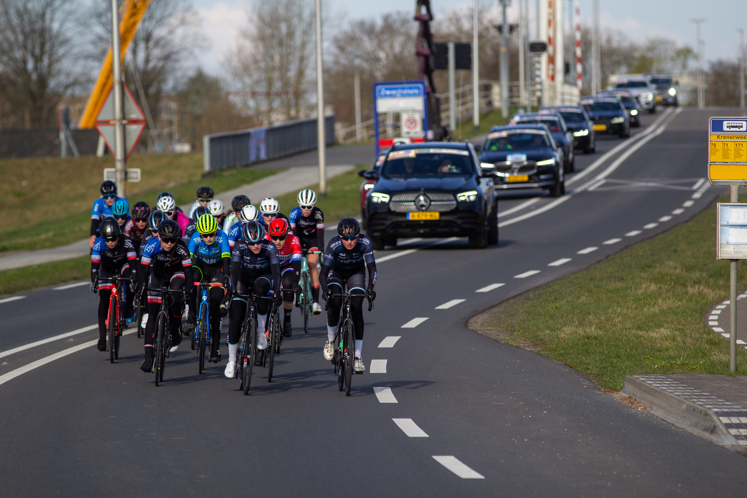 A group of bicyclists compete in a race on a street.