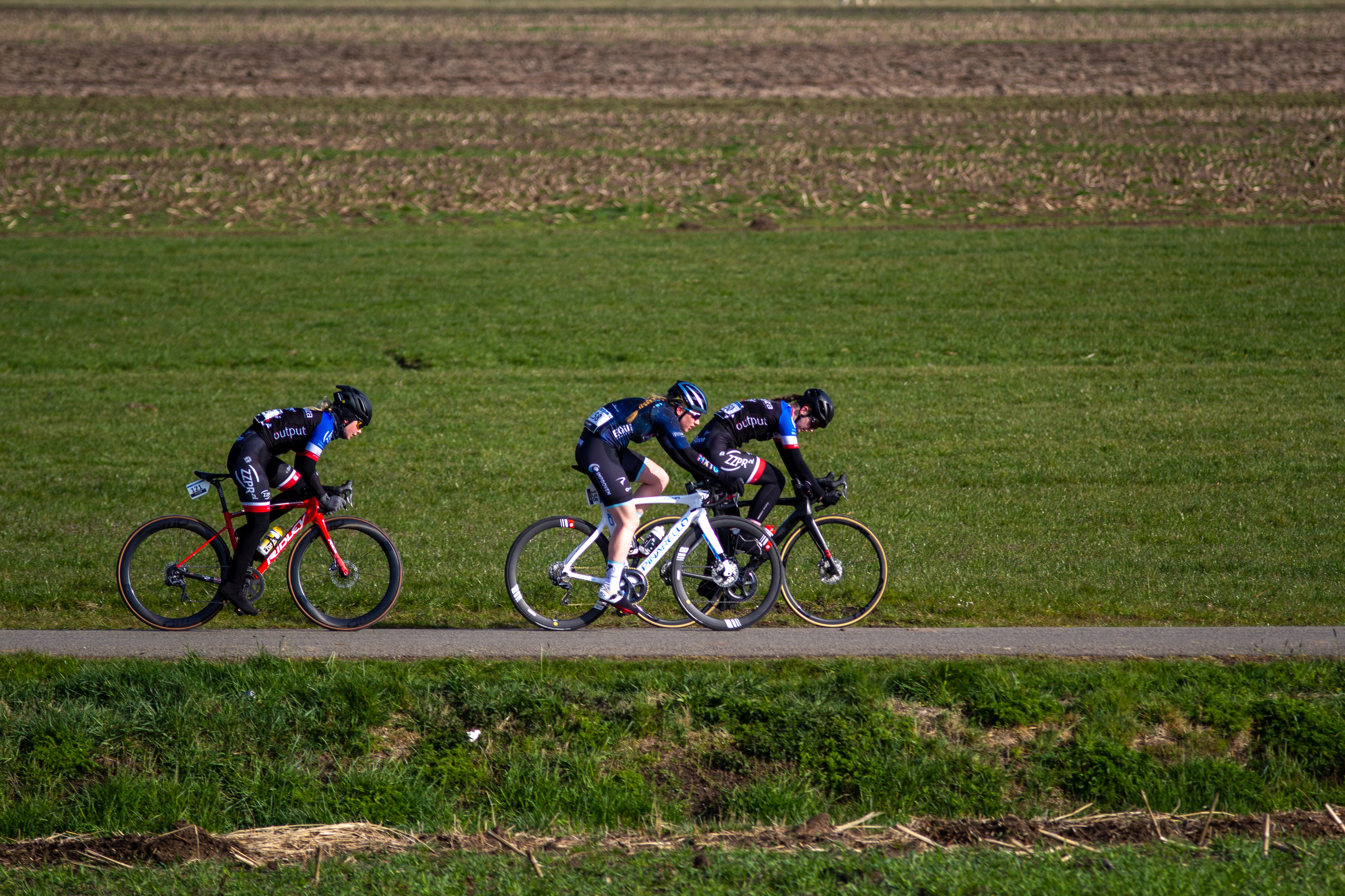 Two cyclists are racing on a path in Noord West Overijssel.