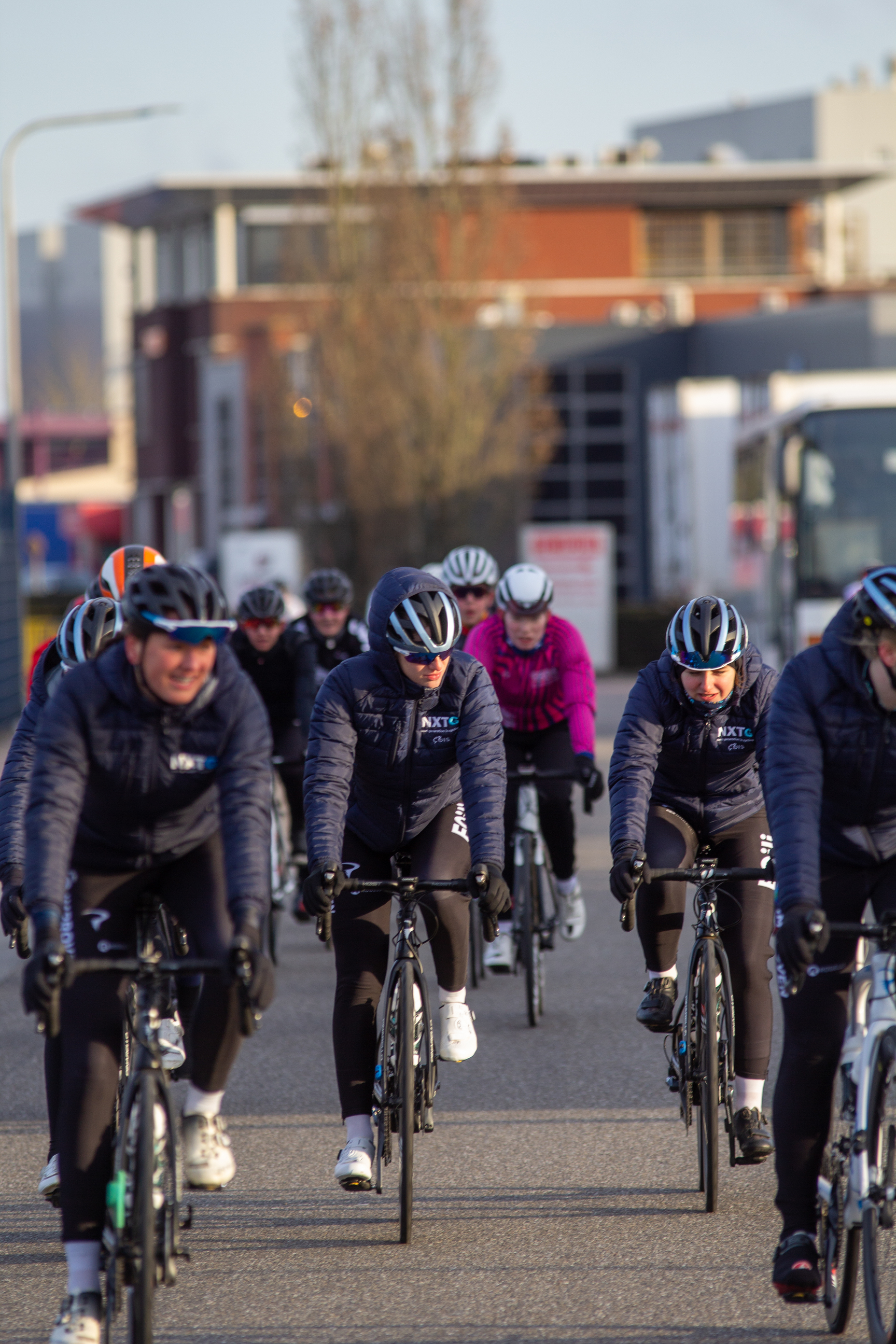 Wielrennen Noord West Overijssel Dames with 5 riders dressed in black on blue bikes.