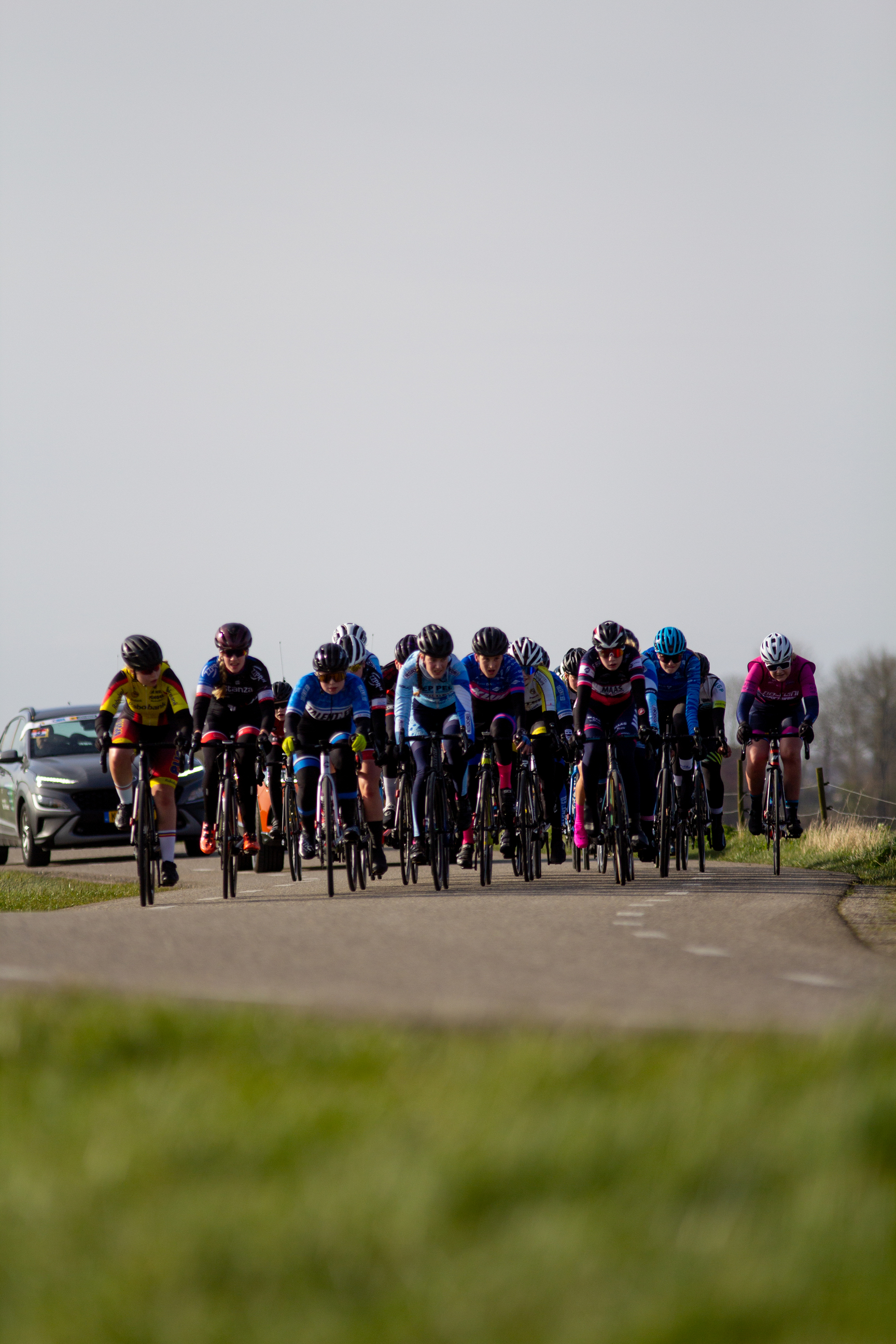 A group of cyclists is riding down a street during a race.