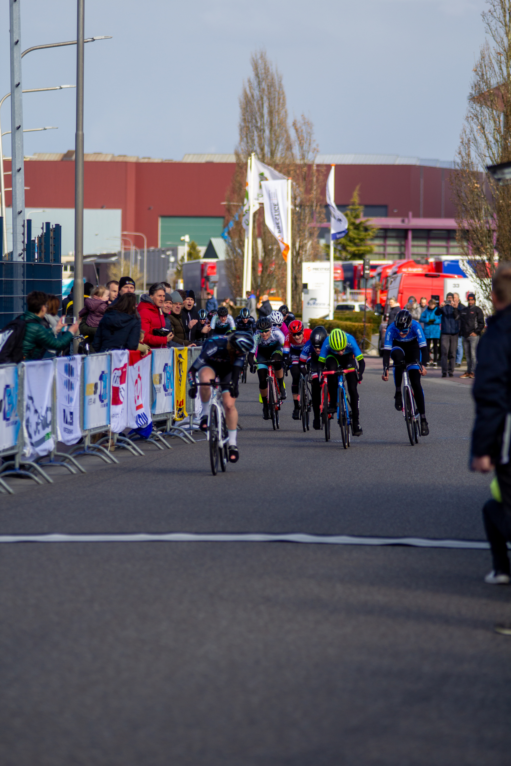 A group of cyclists are participating in the Noord West Overijssel Dames race.