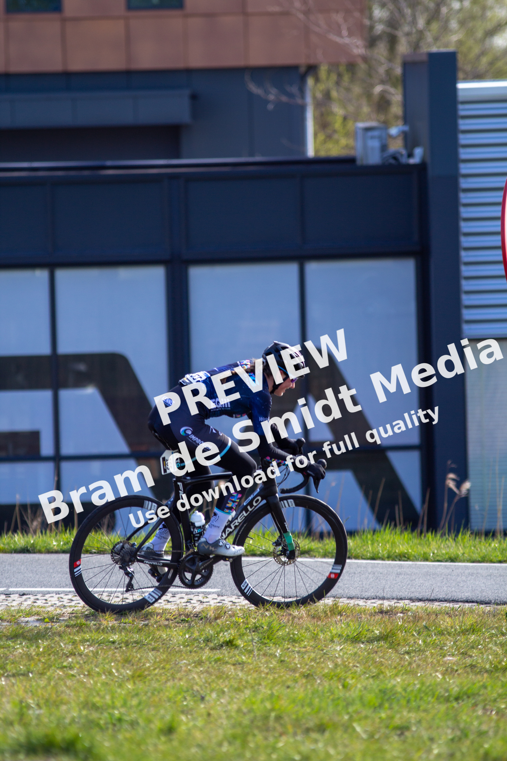 A cyclist is riding a black bike on a road in Overijssel, Netherlands.