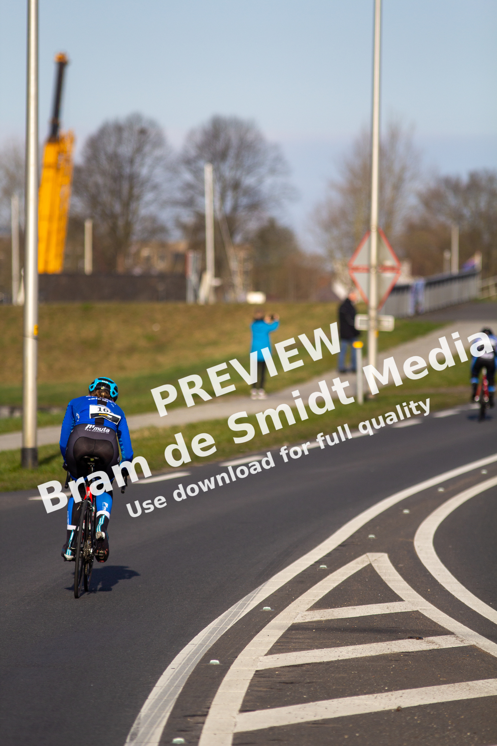 A cyclist on a road with another person in the distance.