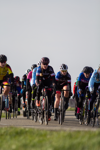 A group of cyclists race down a road in the Netherlands.