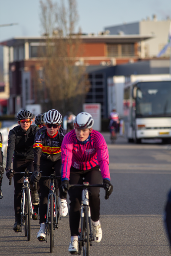 A group of cyclists wearing helmets and riding bikes are participating in a race.