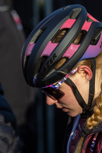 A girl wearing a bike helmet and sunglasses is riding her bike during the Noord West Overijssel event.