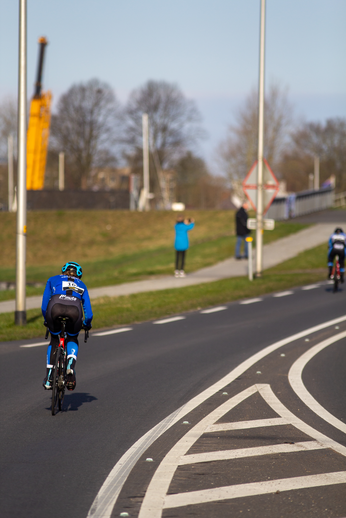 A cyclist on a road with another person in the distance.