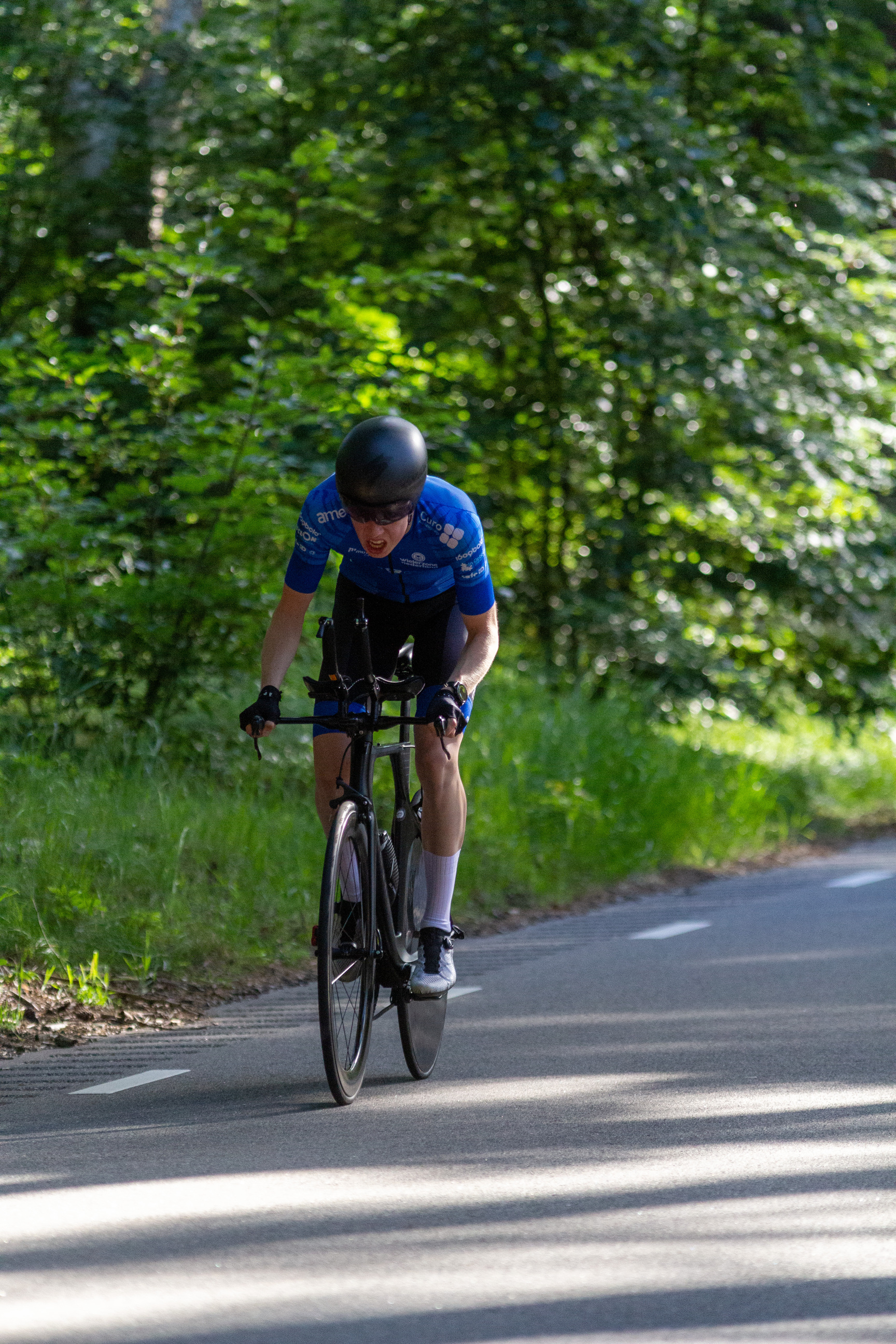 A cyclist wearing a blue shirt and white shorts riding on a bike.