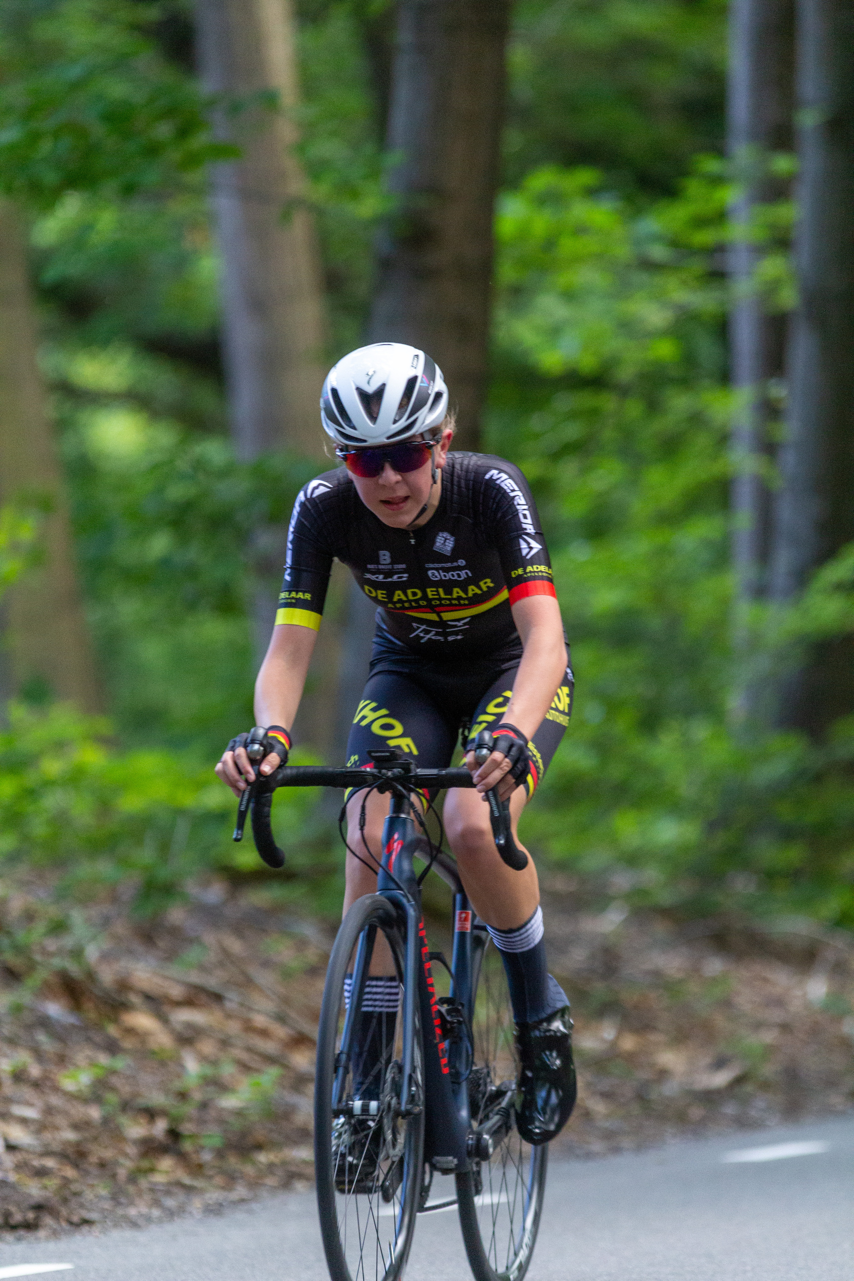 A person in a bike with black and yellow shirt and the number 42 on it.