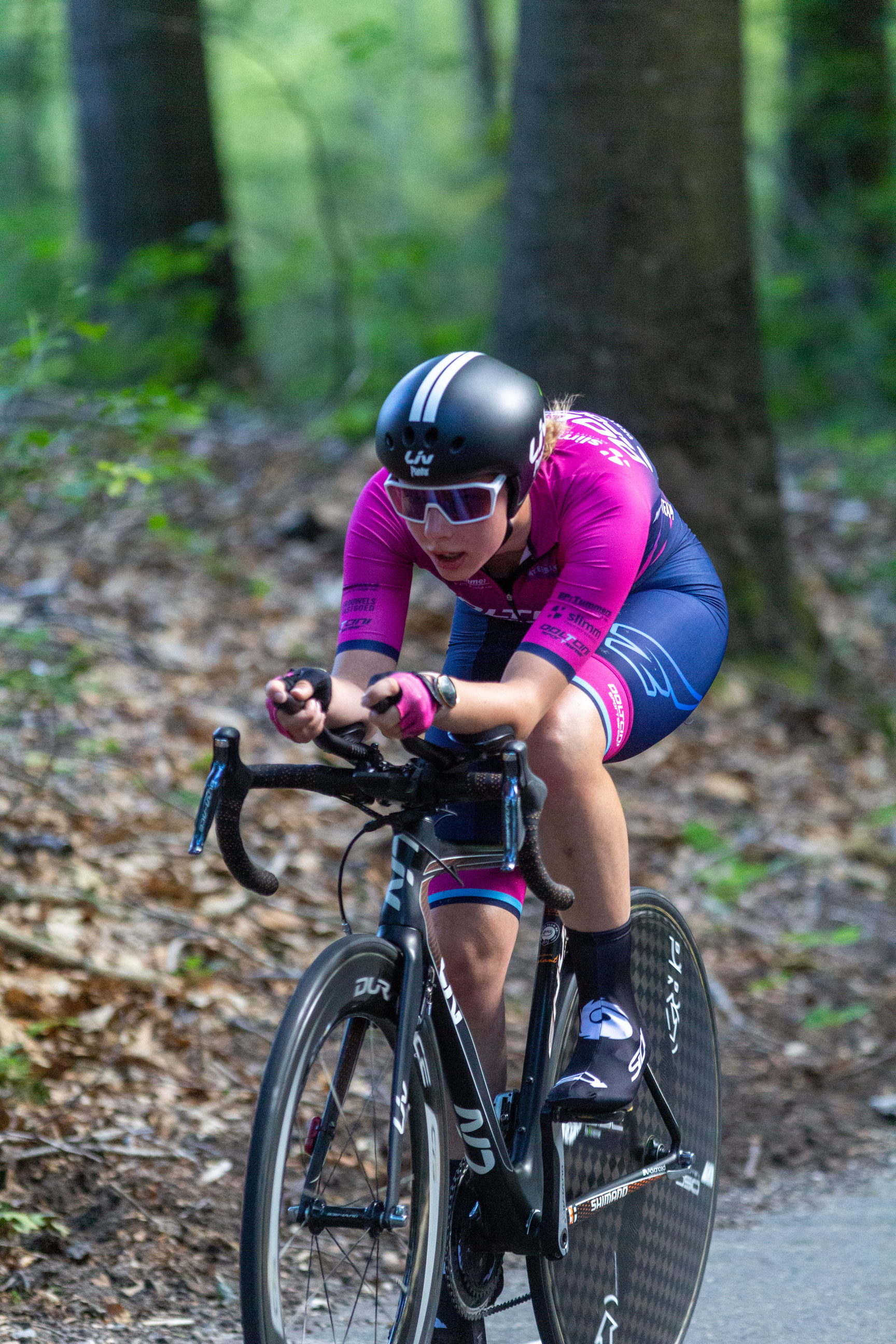 A woman on a bike with her arms extended as if she is in motion.