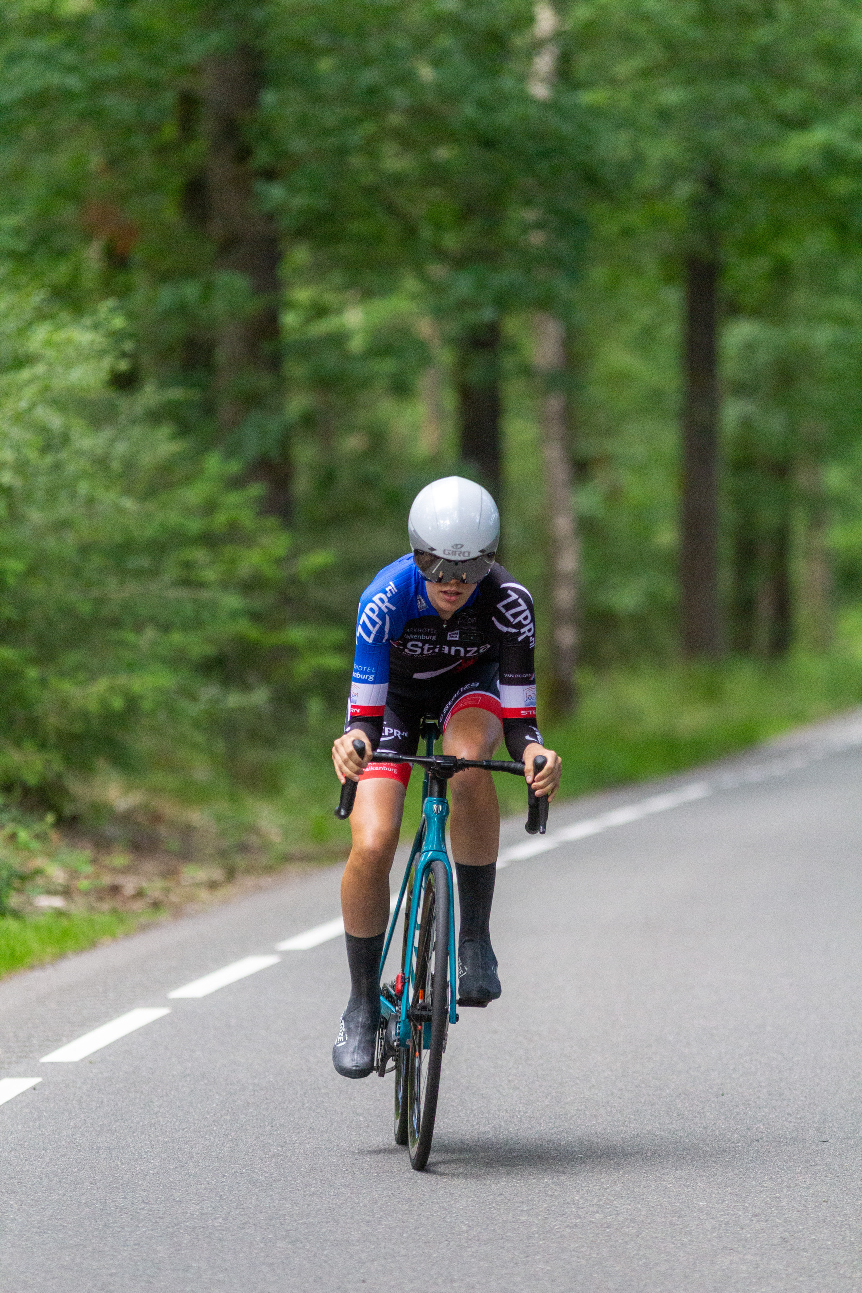 A person riding a bicycle with the words Wielrennen on their jersey.