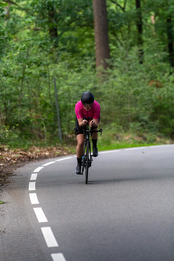 A woman is riding her bicycle down a winding road.