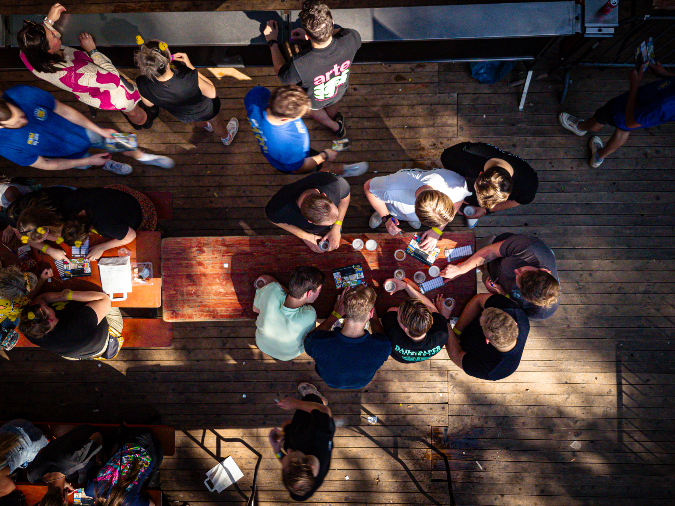 A group of people are sitting around a table and playing a game. The atmosphere seems to be fun and social.