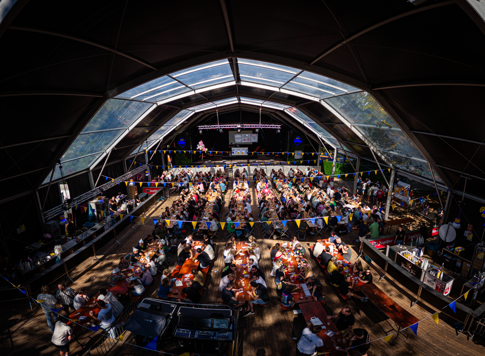 A photo of a crowd in a large building, it's not clear what the crowd is gathered for.