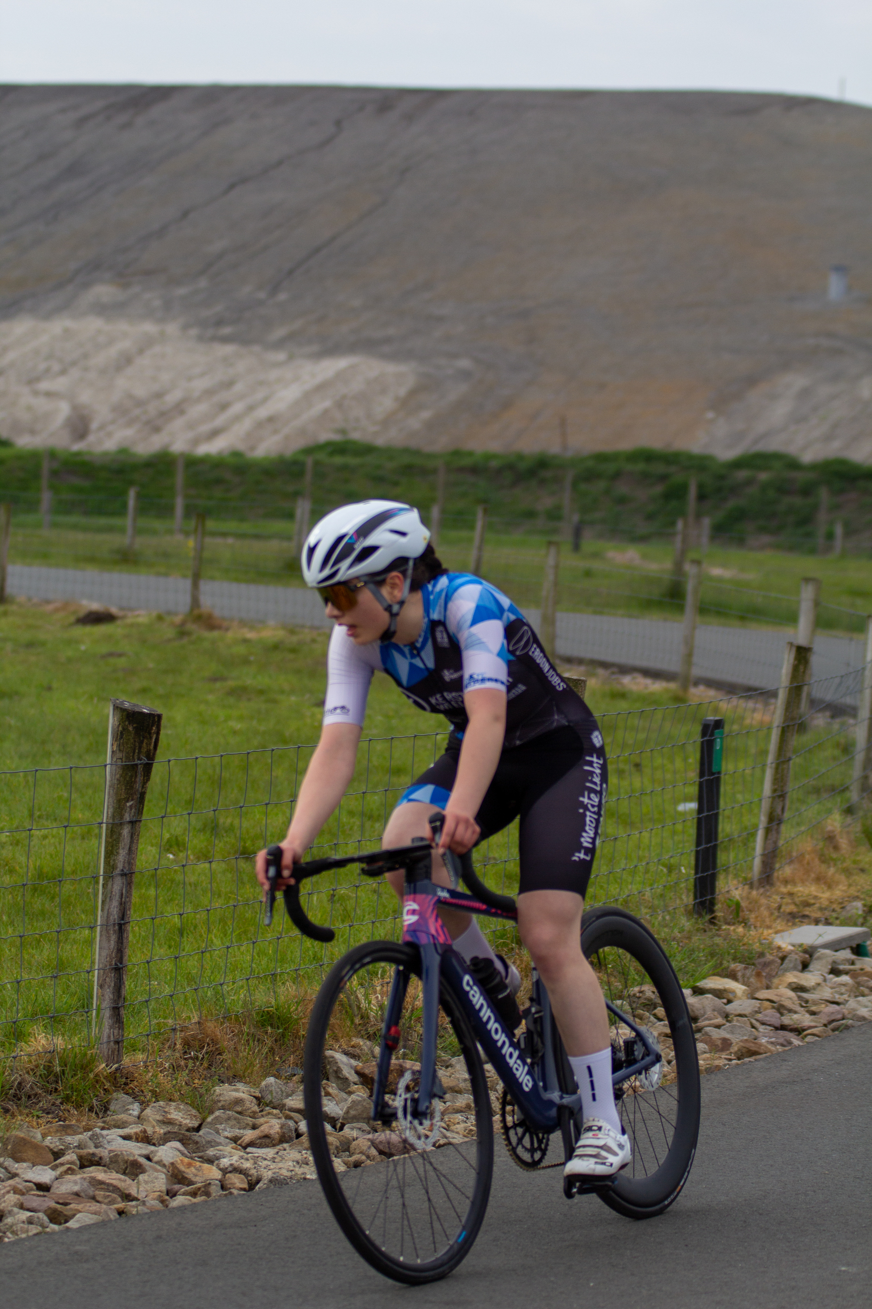 a woman wearing a white helmet riding her bicycle.