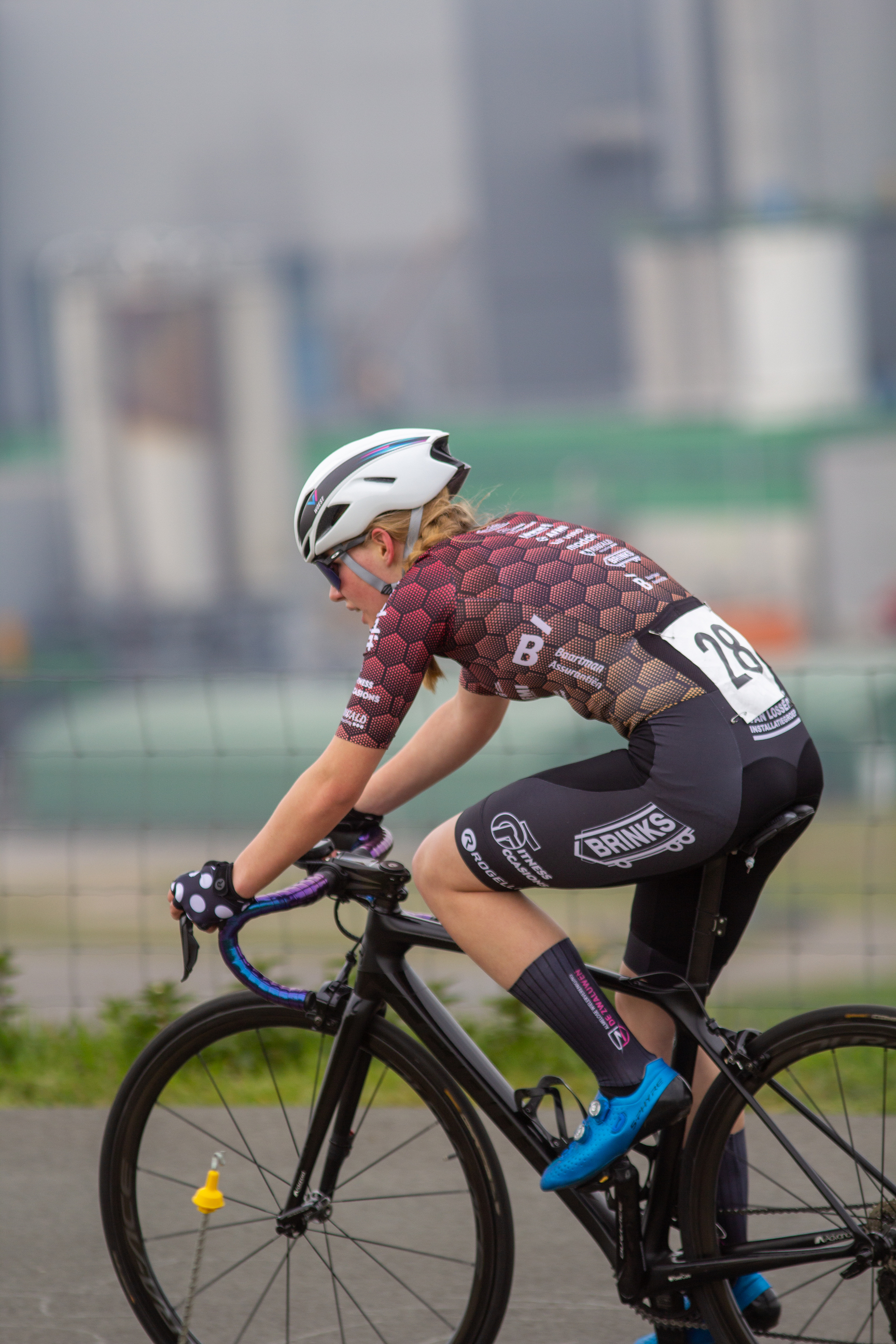 A woman in a racing uniform on a bicycle sponsored by Giant.