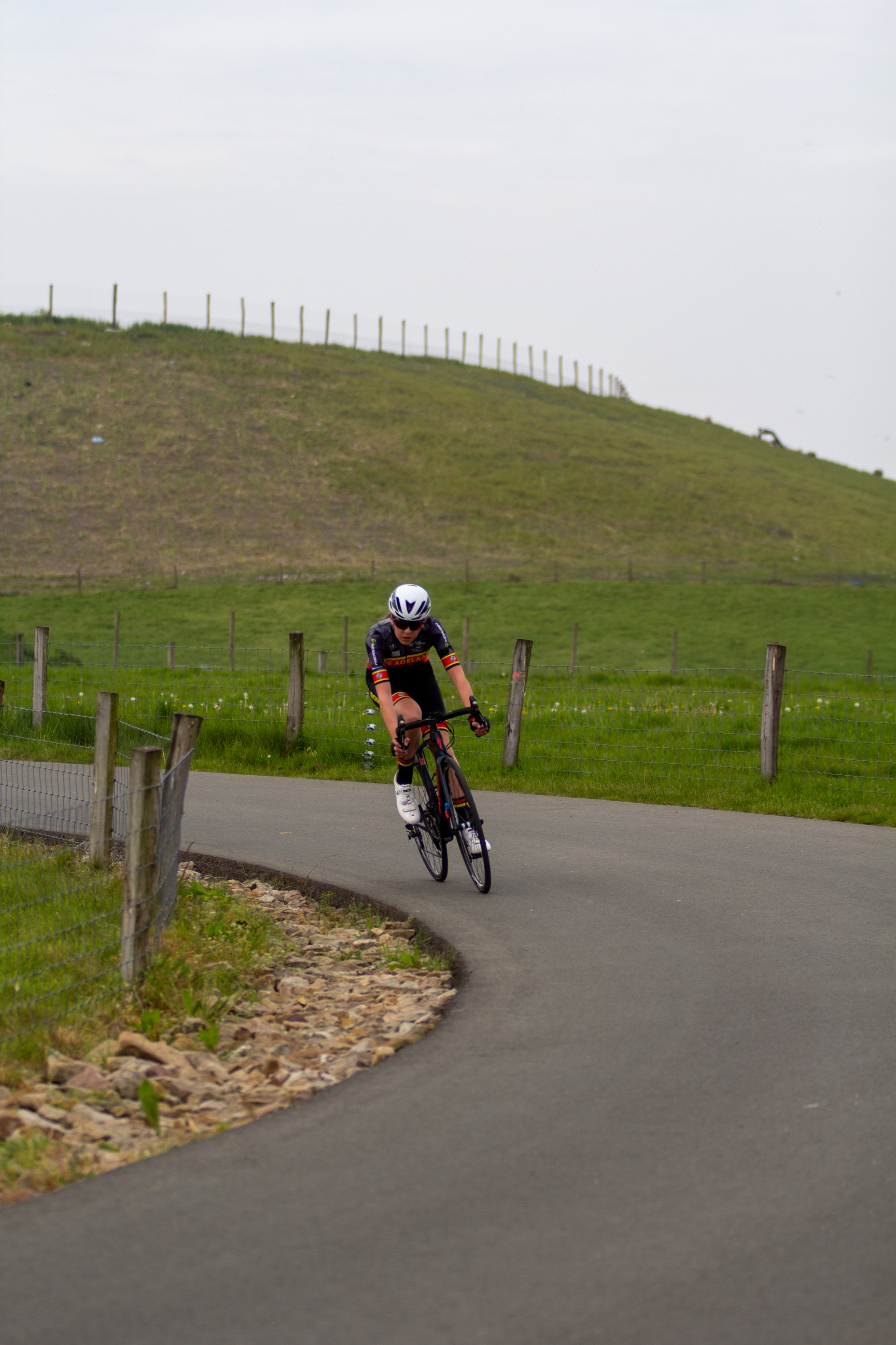 A cyclist wearing a white helmet is riding a bike.