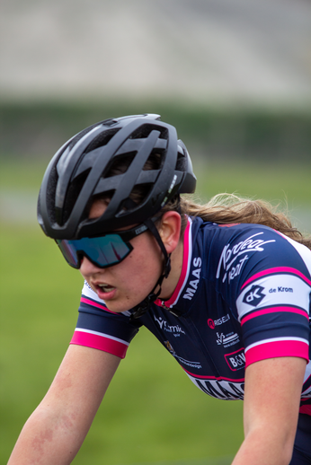 The image is a woman wearing a racing uniform while riding her bike.