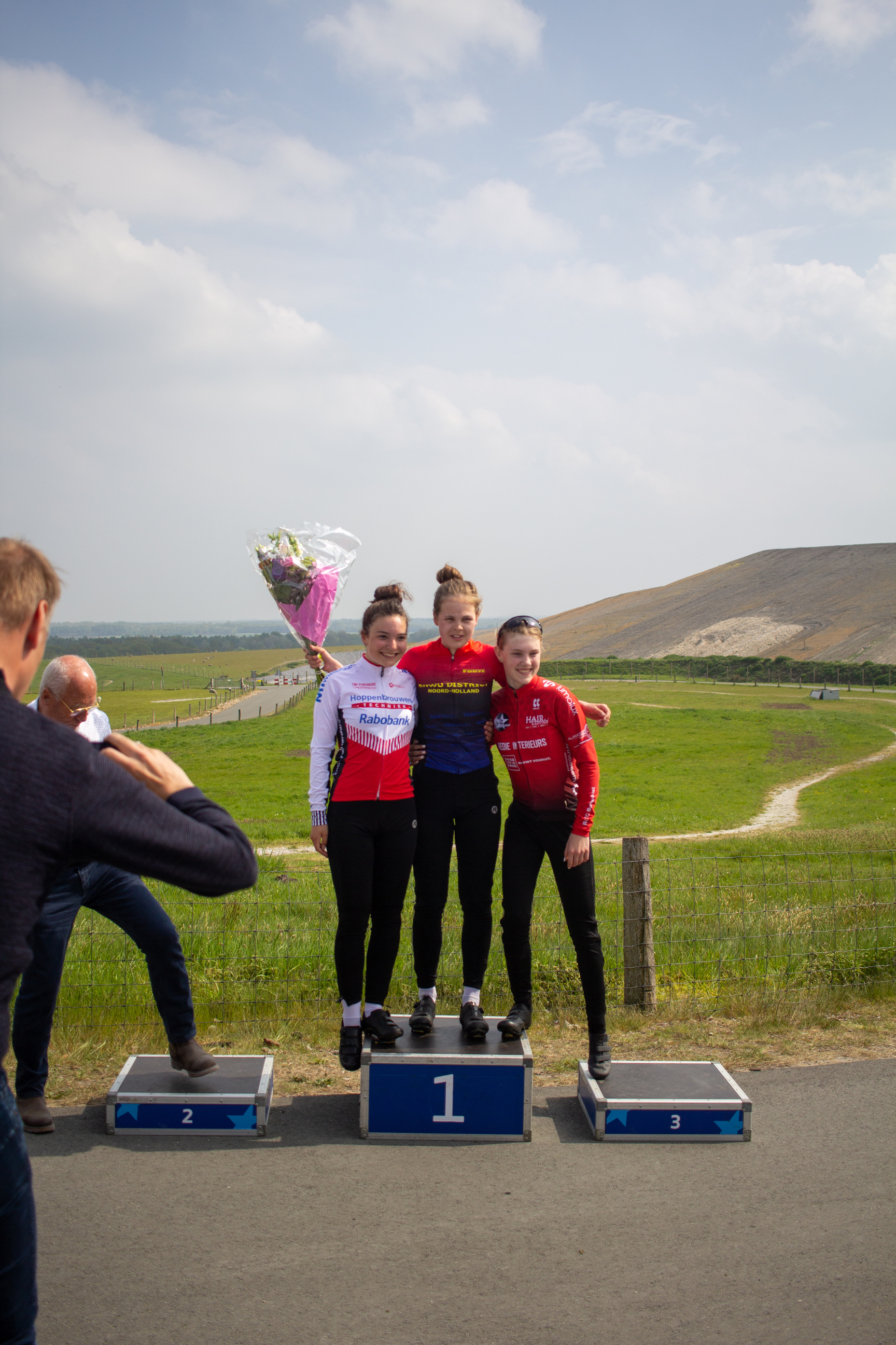 A young woman poses on a podium with her family after a race.