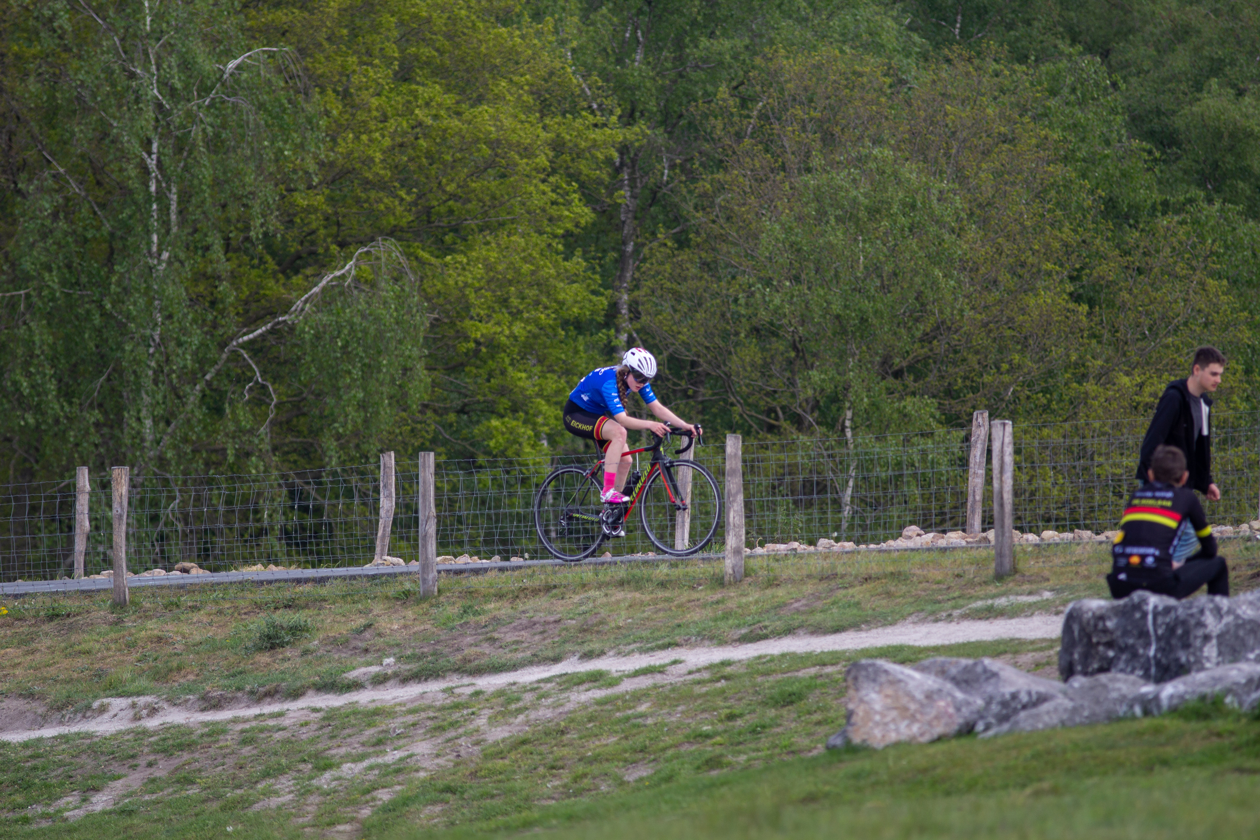 A woman on a bike with the number 21 winds her way down the trail of the Dames Criterium.