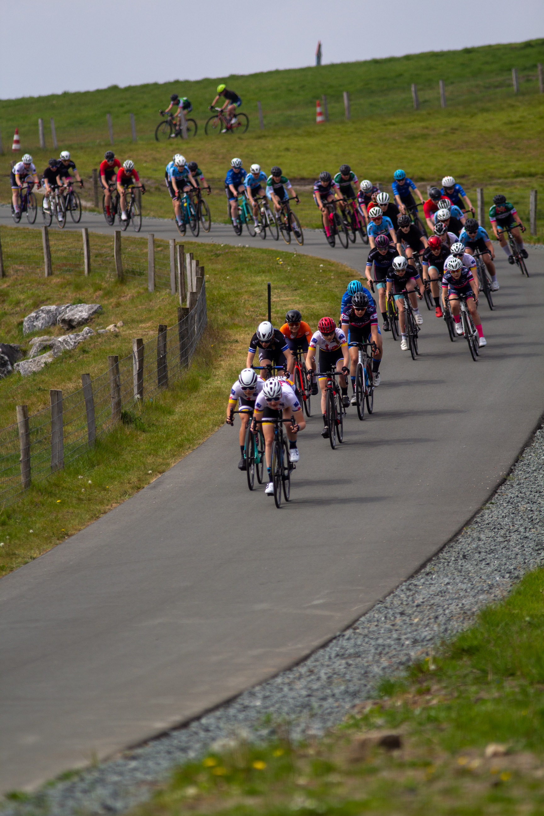 A group of cyclists are riding on a hill during the Dames Criterium.