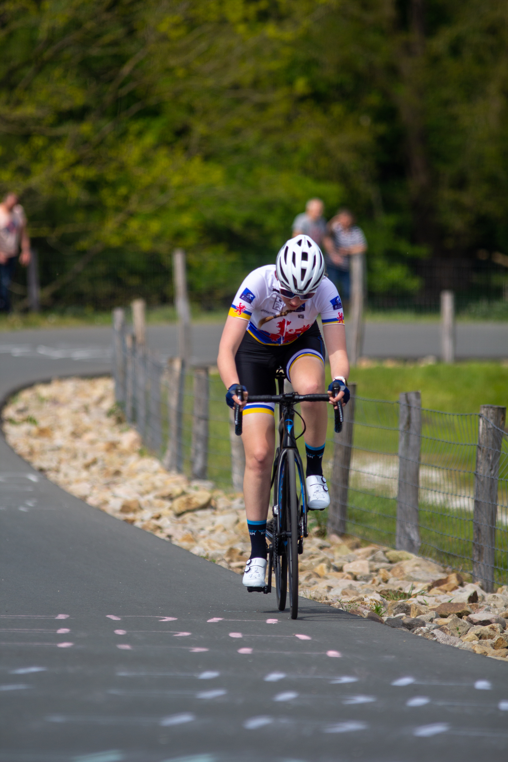 A woman riding a bike down a hill during the Tweedaagse Wielrennen.