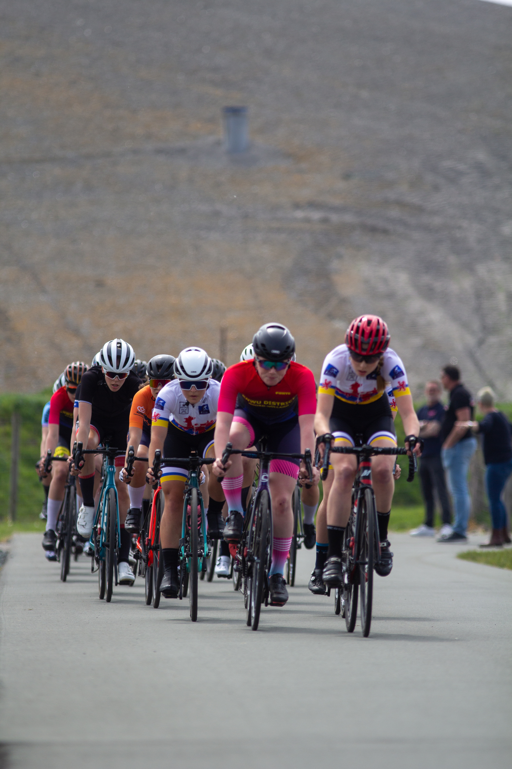 A group of bike racers wearing helmets and jerseys.