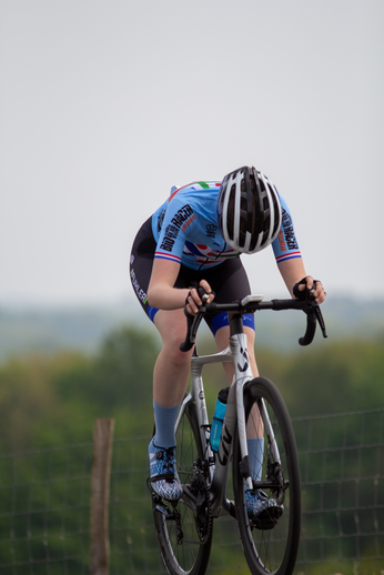 A female cyclist wearing a blue jersey with the words "Hollands N-VA" on it. She has an orange number 10 on her back.