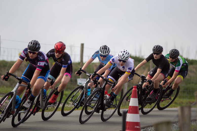 A group of cyclists, a young man and woman are leading the race.