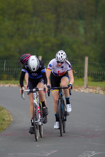 Two women race in a bike race. The leader wears the number 4.