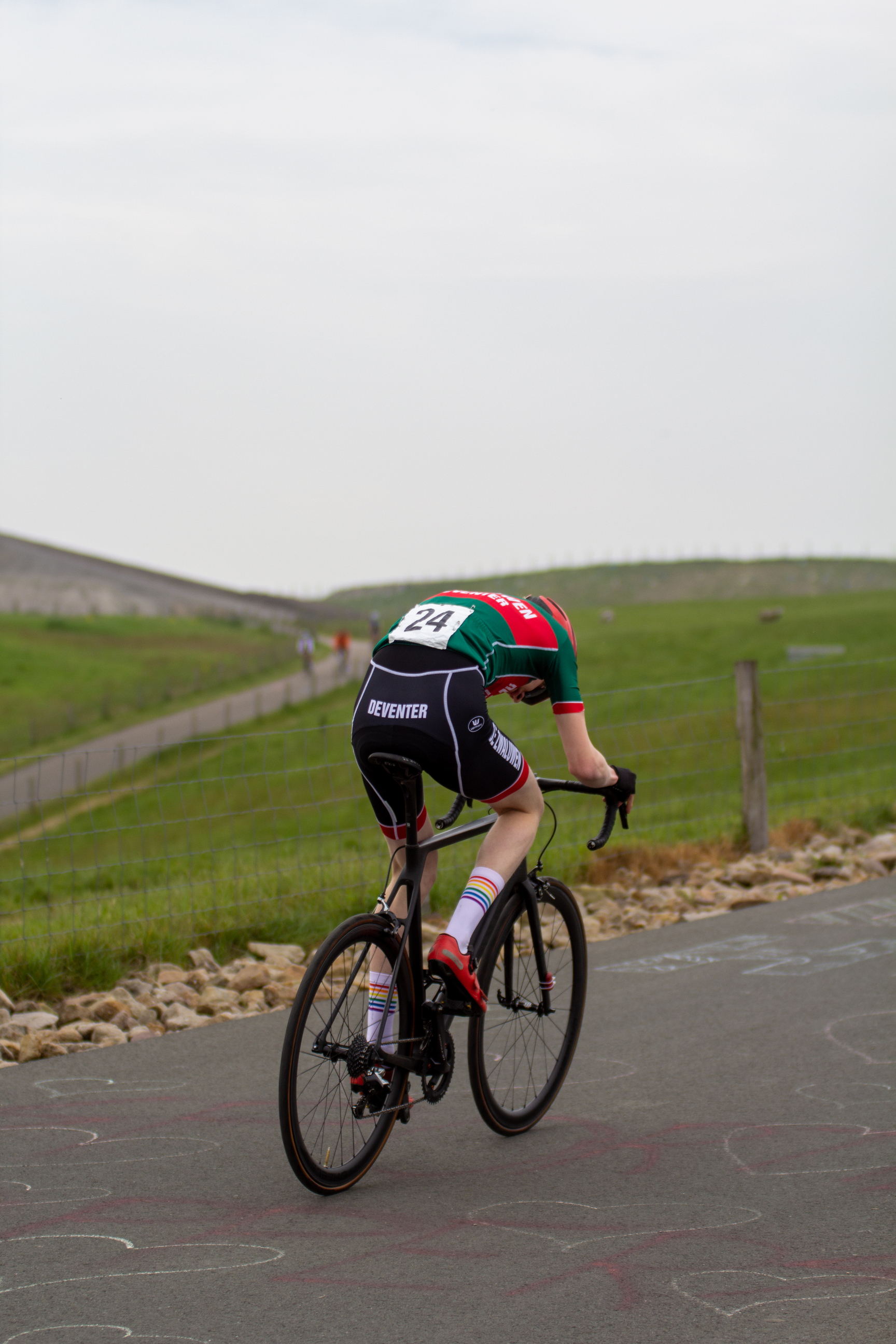 A person riding a bike with the number 5 on their back.