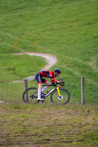 A cyclist is riding his bike down a grassy hill, which has the number 8 on it.