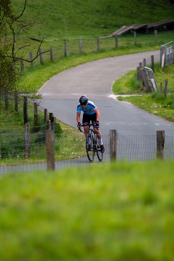 A person on a bicycle wearing a blue and black shirt.