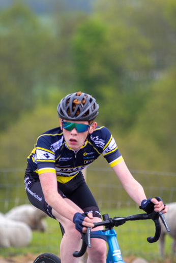 A boy wearing a helmet and riding a bicycle on a road.