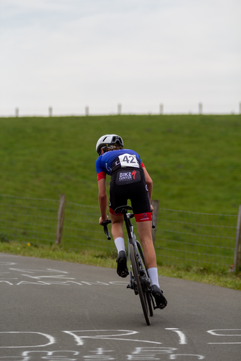 A cyclist on the road has a number 42 and KLM on his jersey.