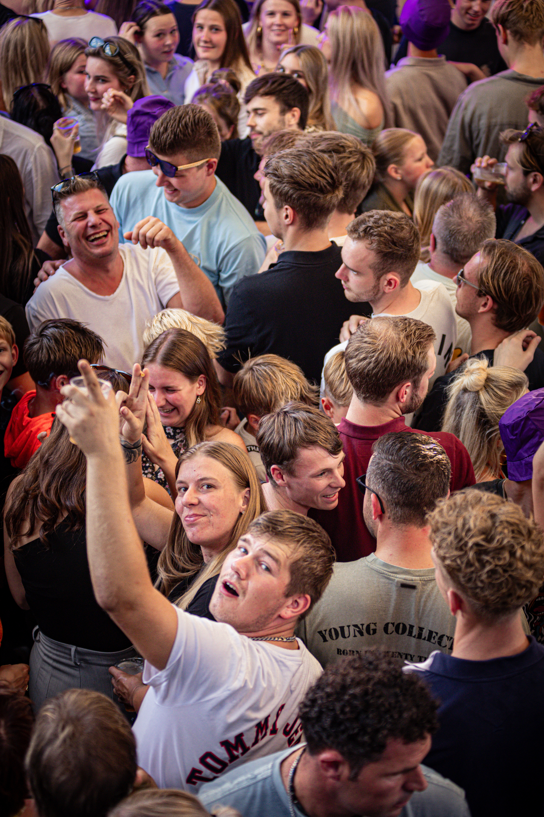 A group of people are at a party, smiling and laughing together.