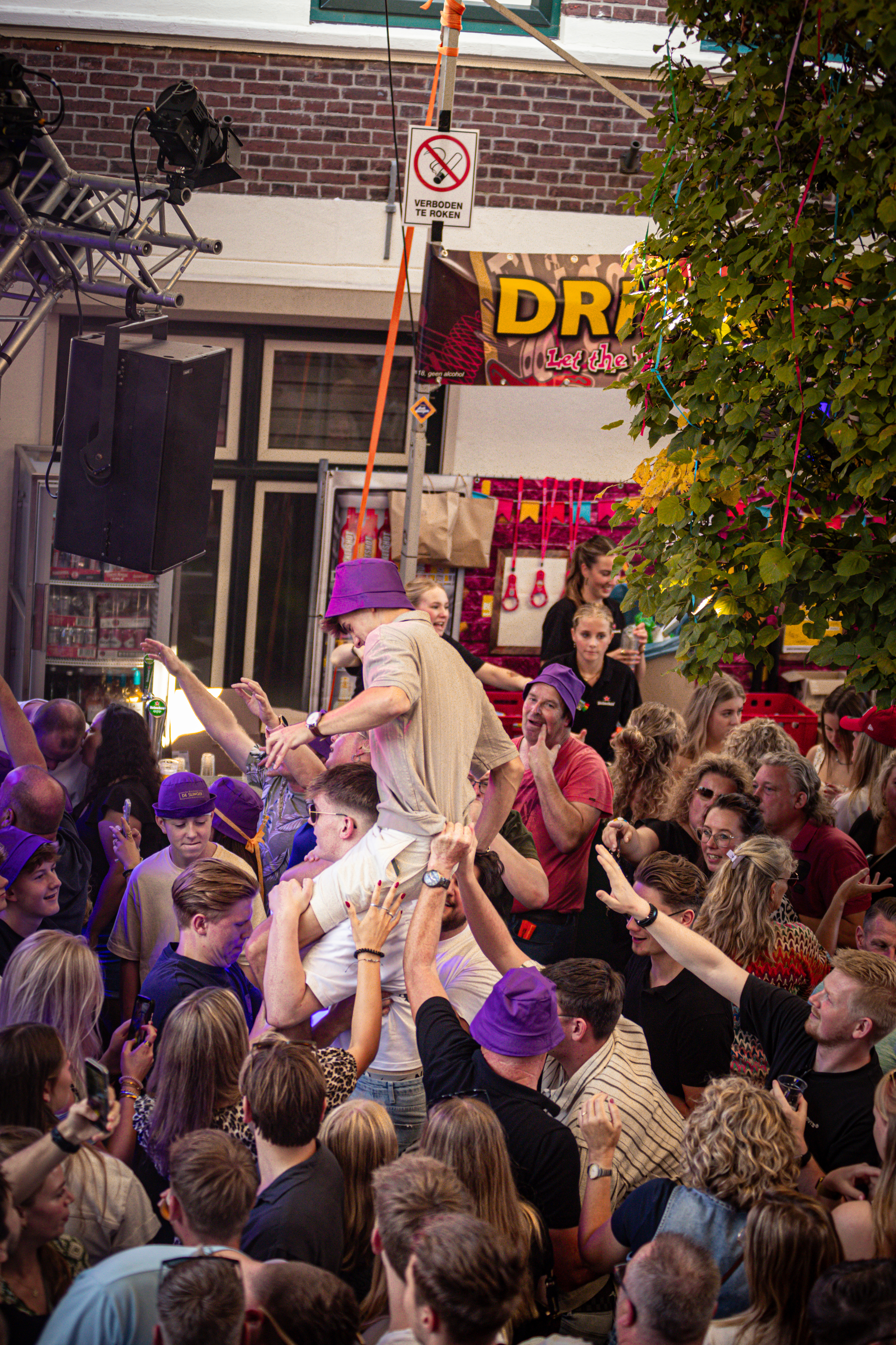 A crowd of people are gathered in a store, cheering for an event.