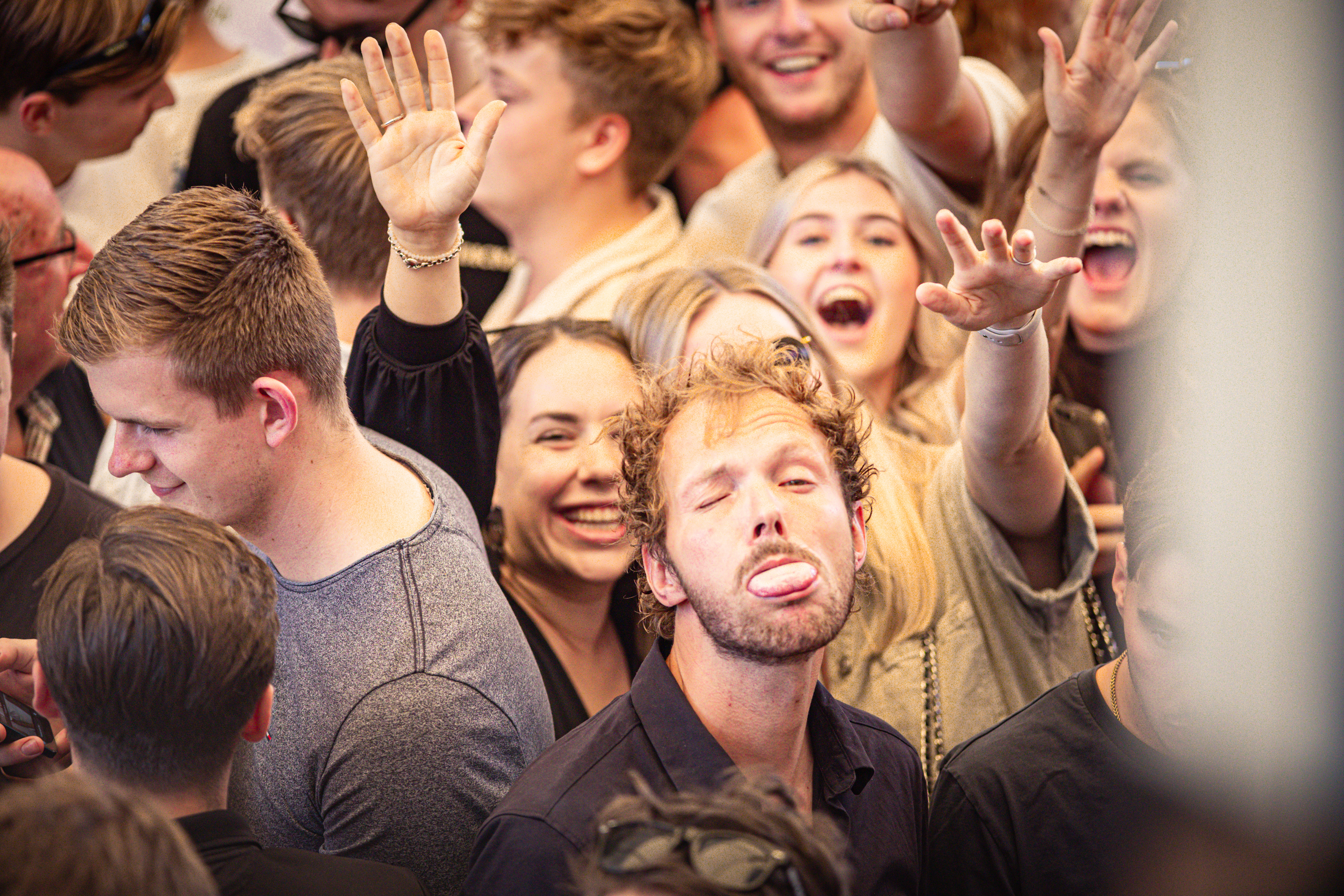 A group of people on stage with one man making a funny face.