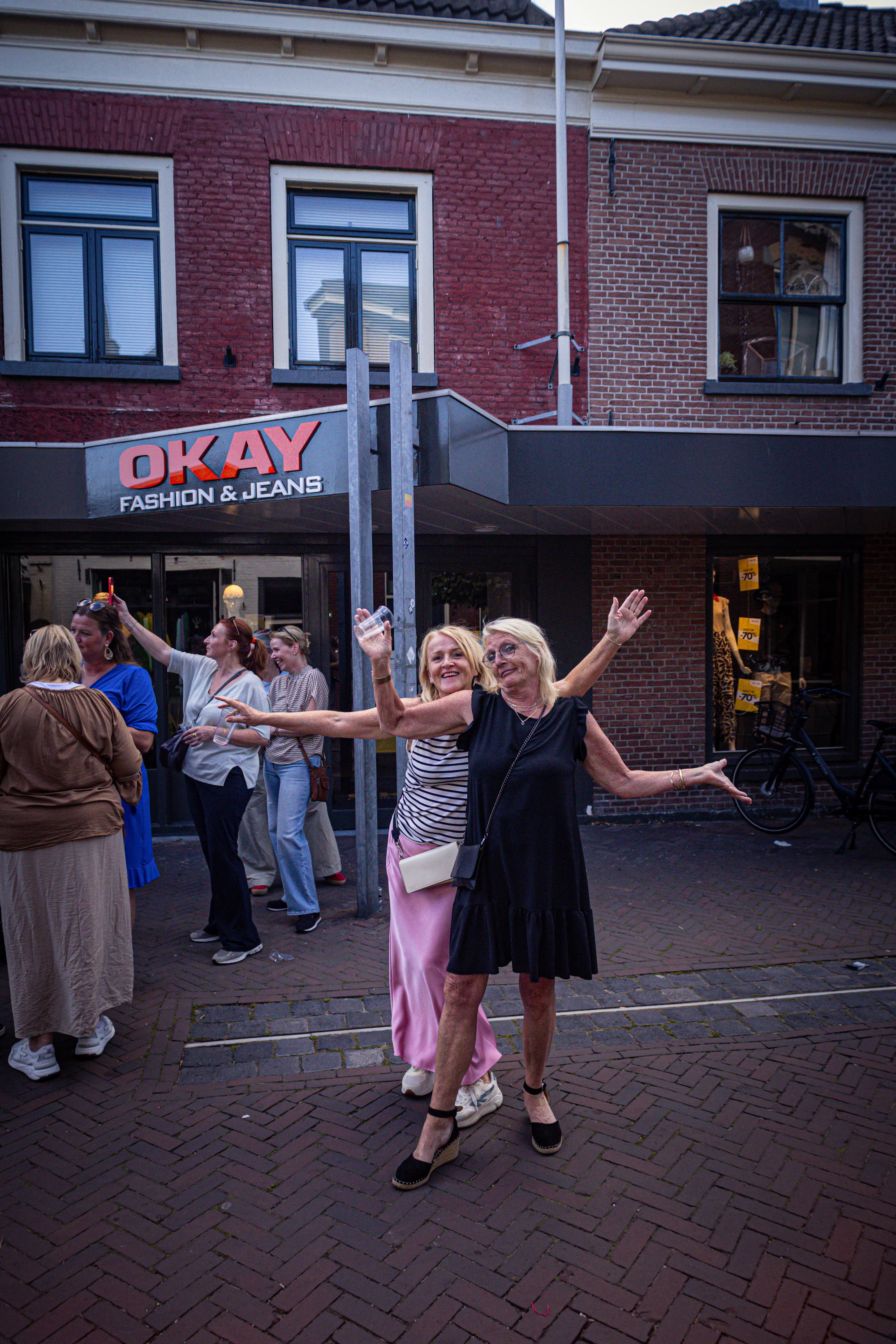 Two women pose for a photo in front of the O.K. Bar & Grill.