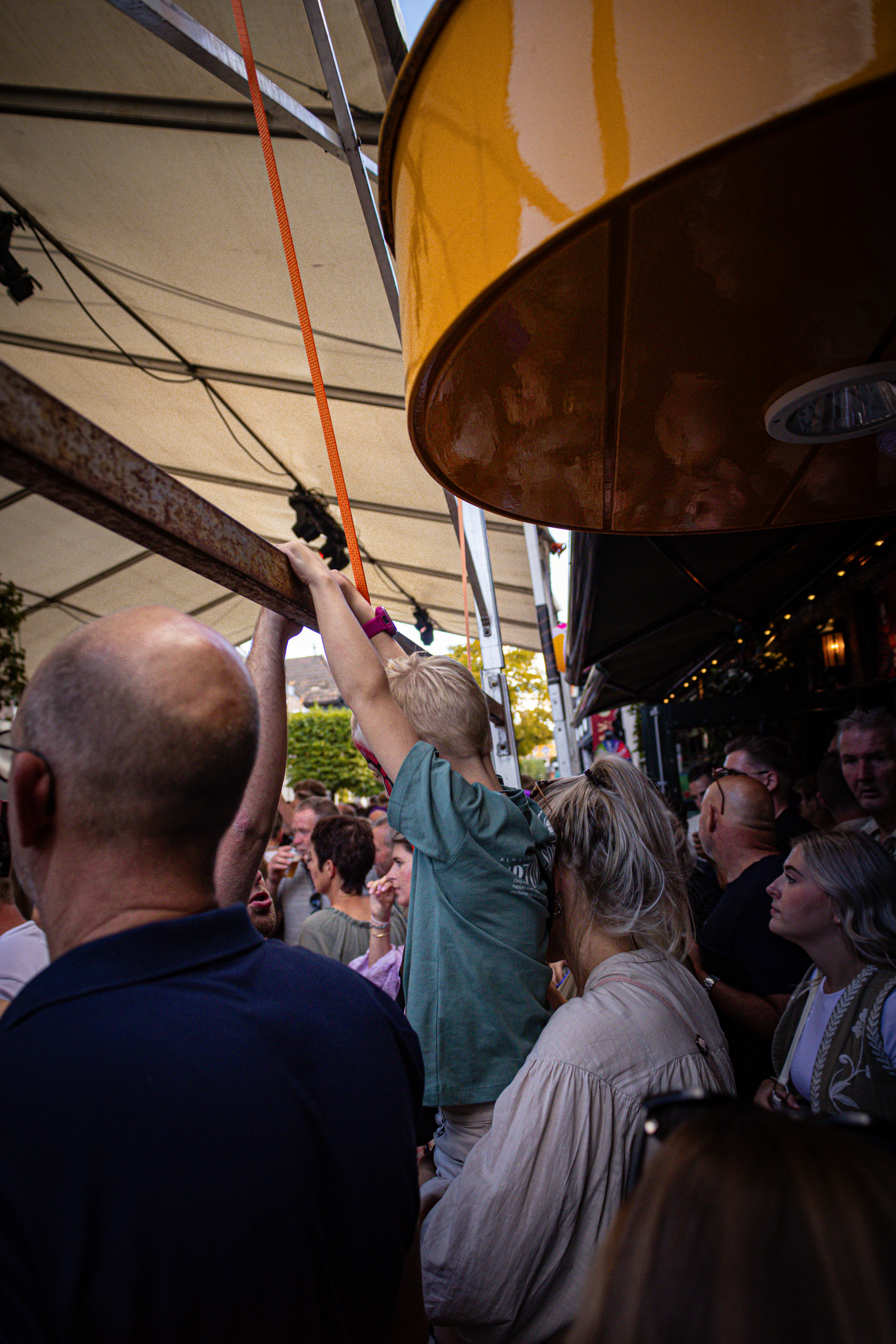 A man in a blue shirt is looking at an aerial view of a tent and the people in it.