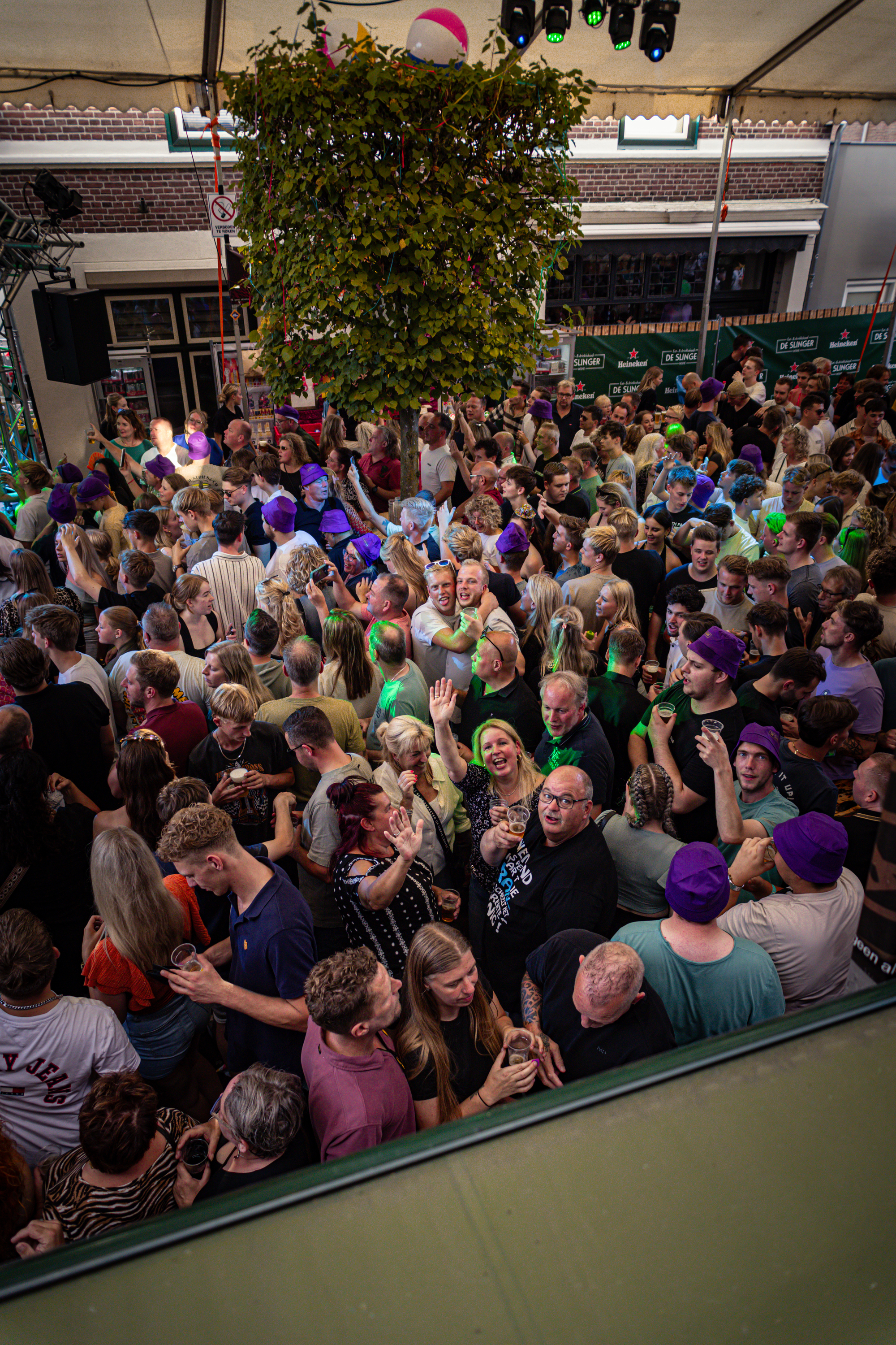 A group of people are standing together at an event with a Christmas tree in the background.