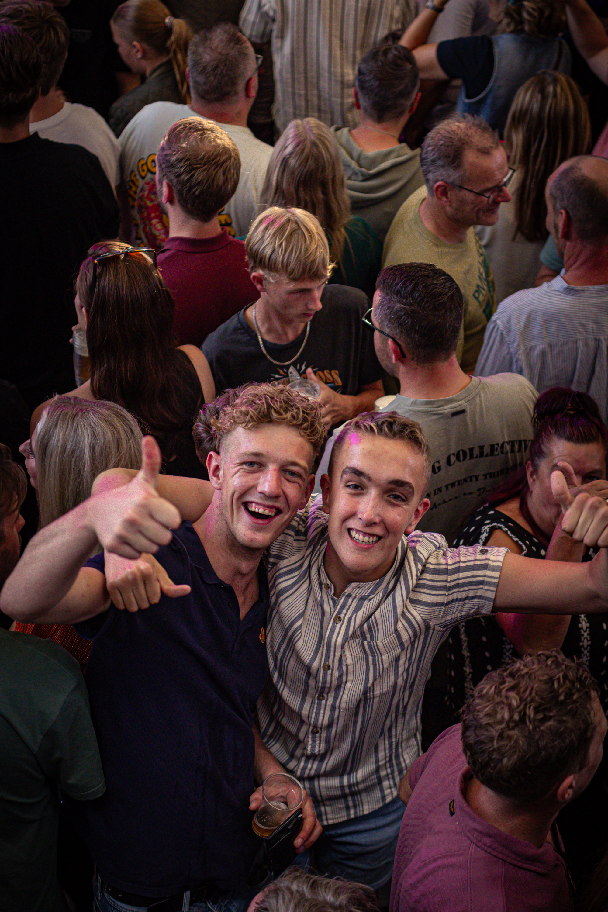 A group of people pose for a photo at an event, one with their hand up as if they are high fiving.