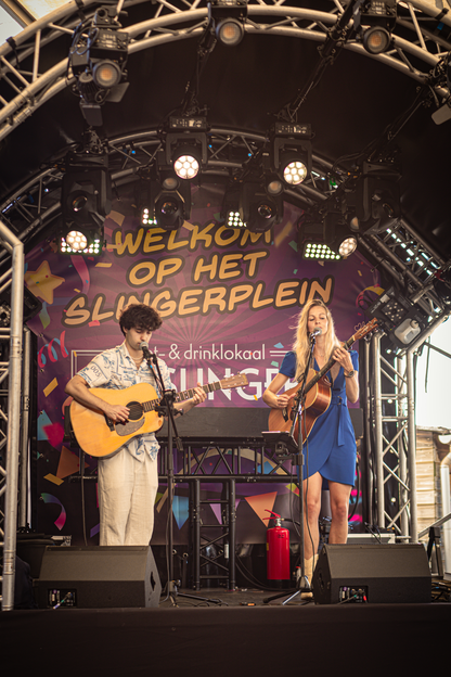 Two people are playing guitar and one is wearing a blue dress.