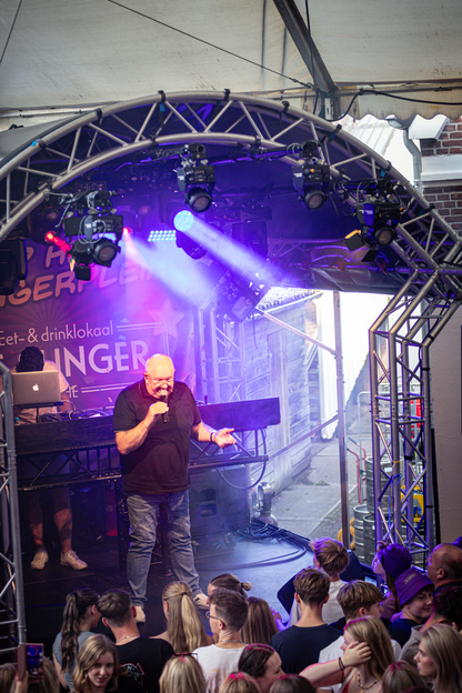 A stage featuring a man in a black shirt on the microphone.